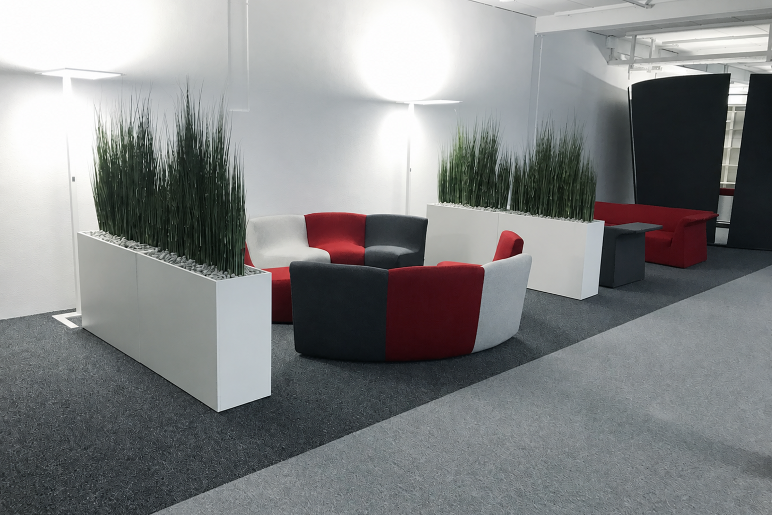 Showroom-Lounge mit modularen Sesseln und Pflanzkübeln
