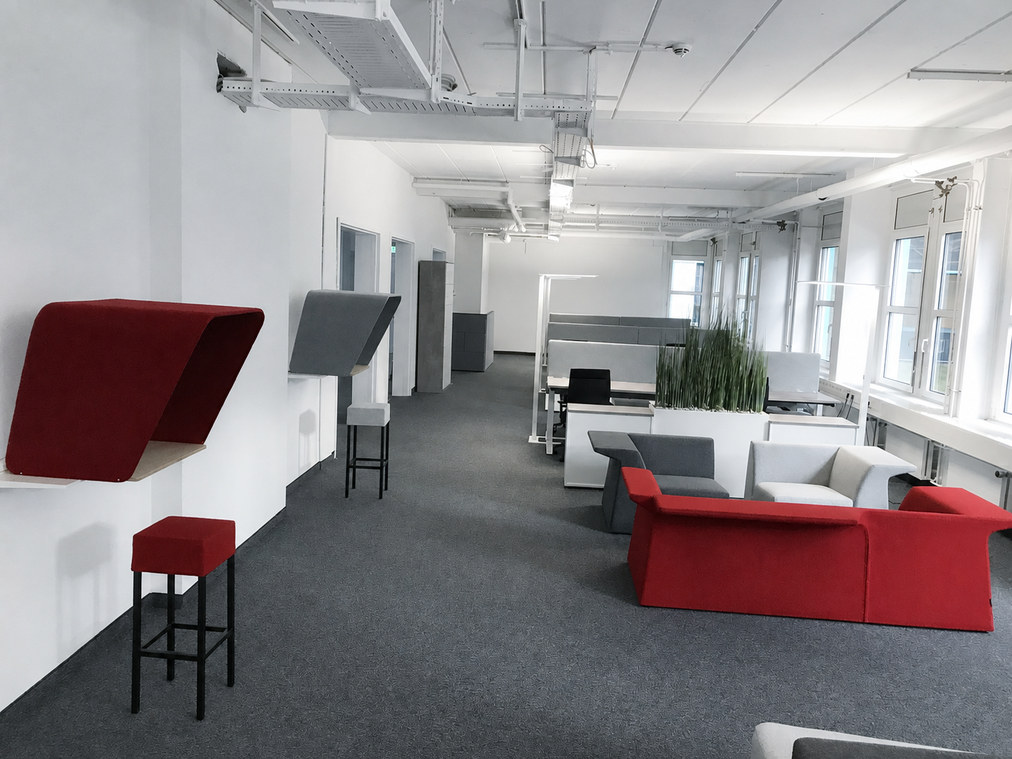 Showroom-Lounge mit roten und grauen Modulsesseln